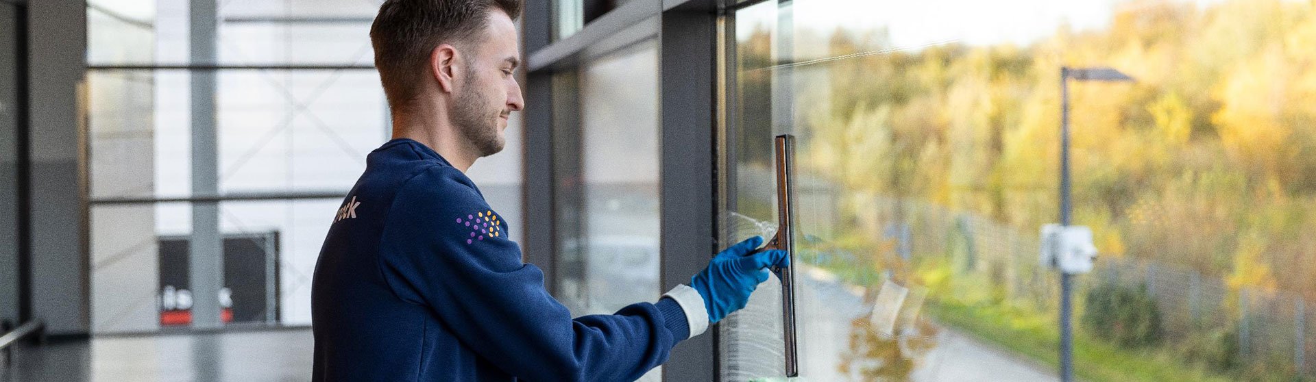 Gebäudereinigung Jobs - Mitarbeiter reinigt eine Fensterfront