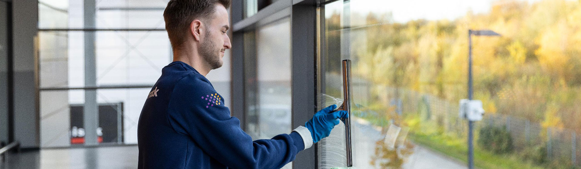 Gebäudereinigung Jobs - Mitarbeiter reinigt eine Fensterfront